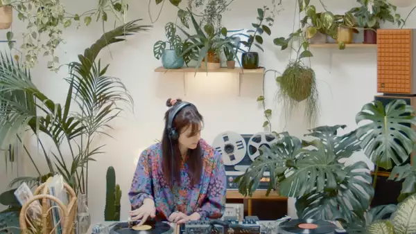 Photo of Lena C DJing surrounded by plants