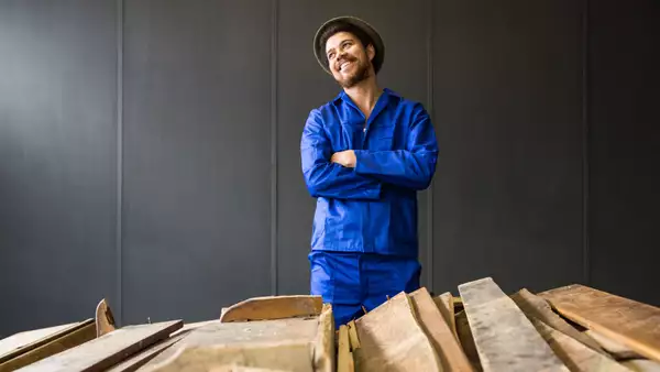 Photographic portrait of Kemang wa Lehulere, stood behind planks of wood