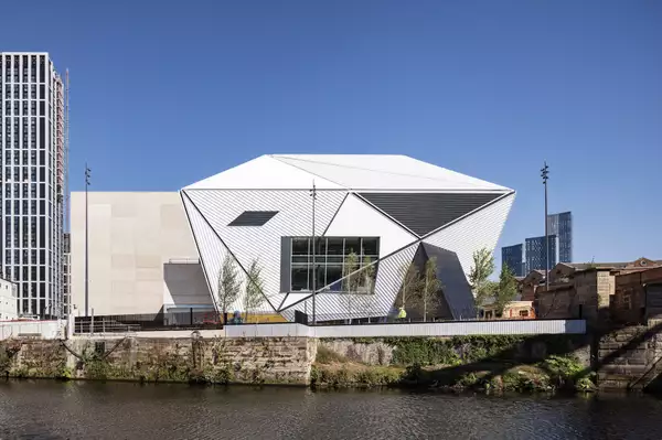 Aviva Studios seen from across the River Irwell on a sunny day
