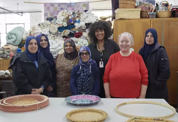 Seven people smiling in a workshop