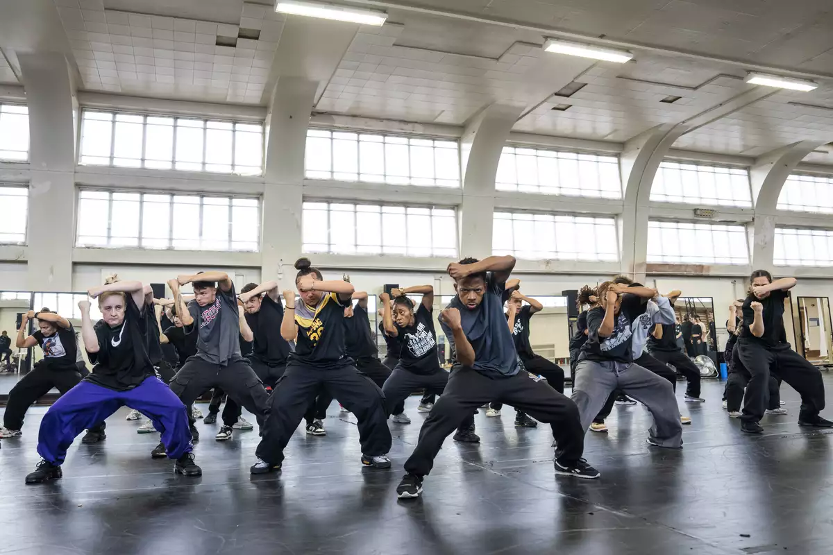 Dancers for Free Your Mind with one arm across their forehead in rehearsals