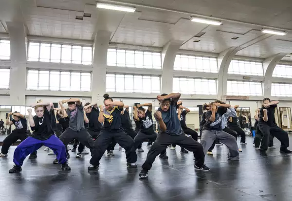Dancers for Free Your Mind with one arm across their forehead in rehearsals
