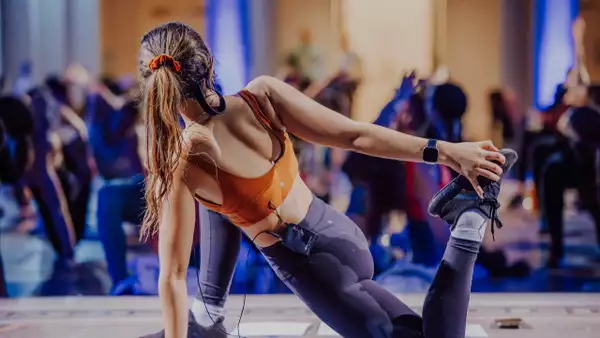 A person doing a yoga pose, leading a class