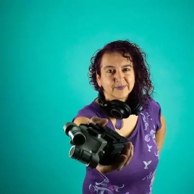 Headshot of Maya Chowdhry on a turquoise background