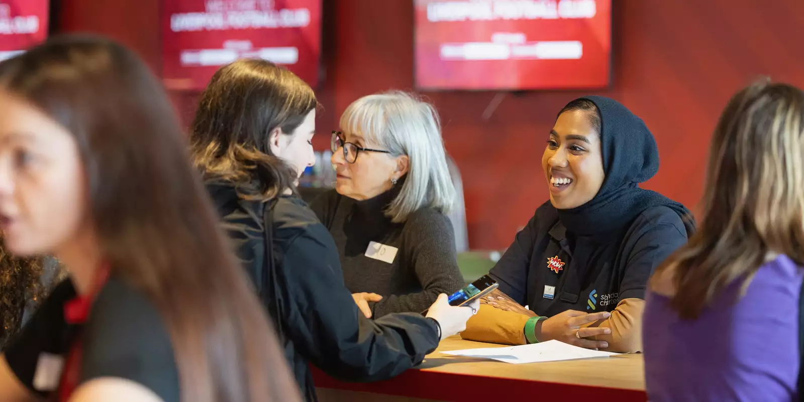 A mentor talking to a younger mentee during a speed mentoring session