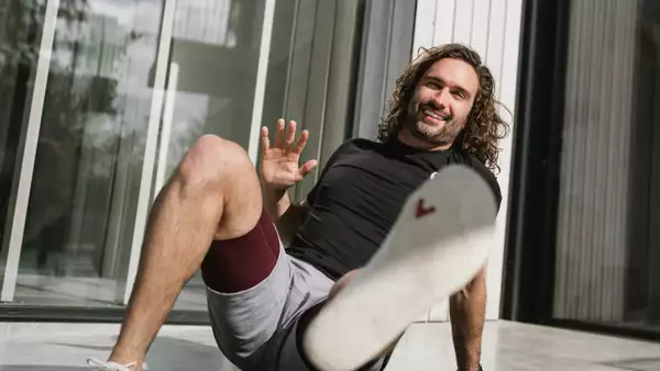 Joe Wicks crouching and looking at the camera