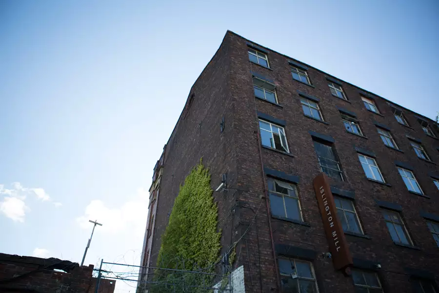 A photograph of the Islington Mill building with blue skies in the background