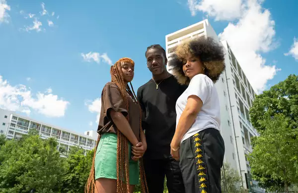 LIVE + BREATHE climate campaigners outside of a tower block with greenery in the background