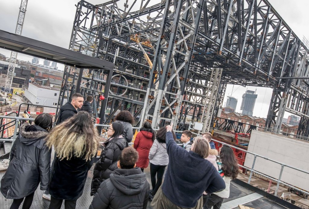 High School students on the construction site of The Factory with members of the MIF team