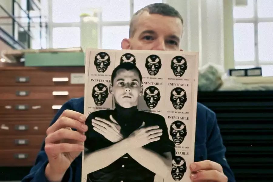 Russell Tovey holding a black and white photograph of David Robilliard