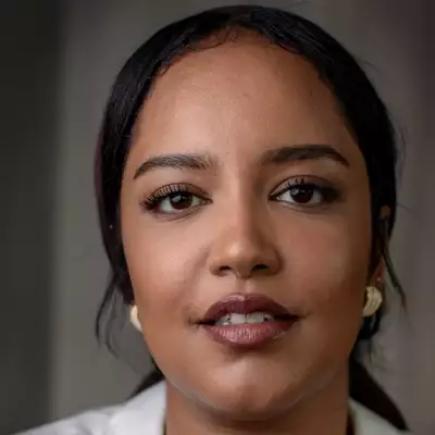 Headshot of Sara Abanur wearing a white shirt and gold earrings