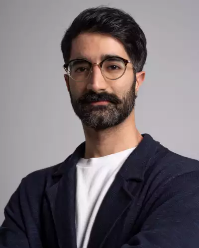 Headshot of Sadra Tehrani wearing a white top and dark blue jacket