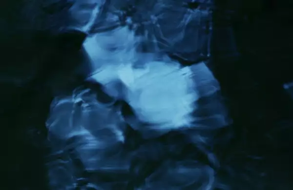 This image has an abstract, fluid-like pattern with deep blue and black tones, creating a sense of flowing water or rippling textures.