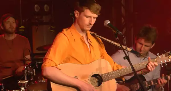 Bay Bryan performing with a guitar