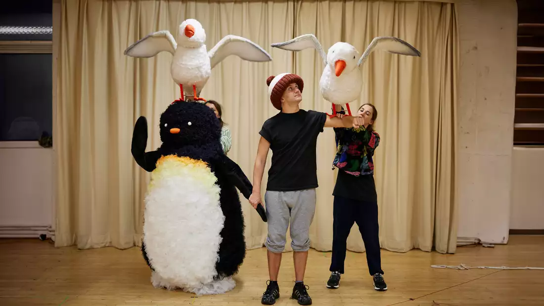 Puppeteers with a penguin and two seagull puppets